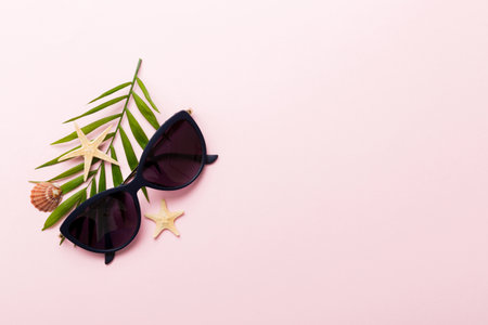 sunglasses with seashell lying on table background. Sunglasses on summer background. Top view flat lay with copy space for text.の写真素材