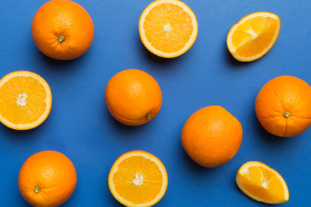 Fruit pattern of fresh orange slices on colored background. Top view. Copy Space. creative summer concept. Half of citrus in minimal flat lay.の写真素材