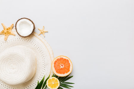 Top view of various seashells placed near colorful fruit and stylish summer accessories on table background. Summer concept. Flat lay. Top view with copy space for text.の写真素材