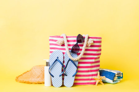 Stylish bag with beach accessories. Summer holiday concept. beach bag with straw hat with space for text.の写真素材