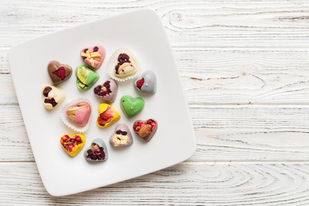Plate with different chocolate on colored background. Assortment of fine chocolates top view with copy space Health and obesity concept.の写真素材