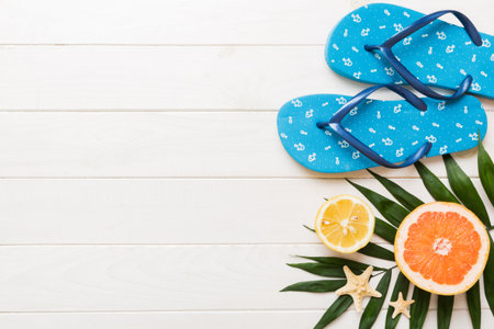 Top view composition of flip flops placed with beach accessories top view on table background....