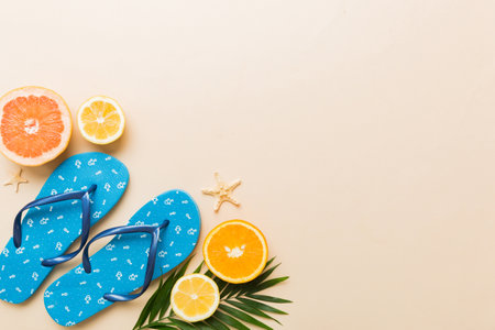 Top view composition of flip flops placed with beach accessories top view on table background....