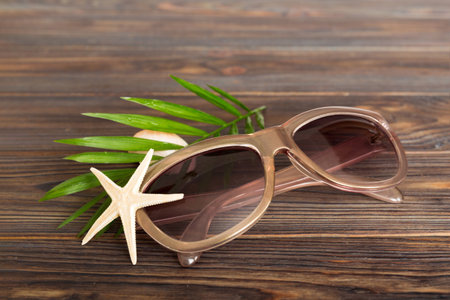sunglasses with seashell lying on table background. Sunglasses on summer background. Top view flat lay with copy space for text.の写真素材