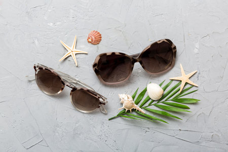 sunglasses with seashell lying on table background. Sunglasses on summer background. Top view flat lay with copy space for text.の写真素材