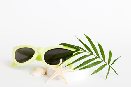 sunglasses with seashell lying on table background. Sunglasses on summer background. Top view flat lay with copy space for text.の写真素材