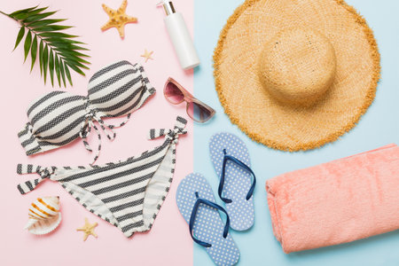 Woman swimwear and beach accessories flat lay top view. Top view with bikini outfit on color background. Vacation concept copy space.の写真素材