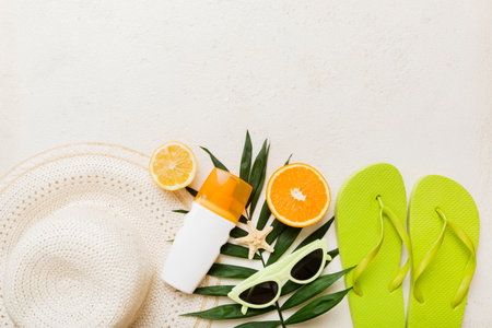 Top view of various seashells placed near colorful fruit and stylish summer accessories on table background. Summer concept. Flat lay. Top view with copy space for text.の写真素材