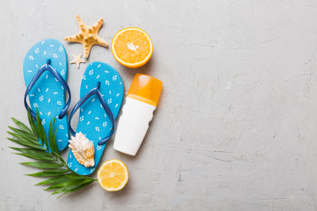 Top view composition of flip flops placed with beach accessories top view on table background....