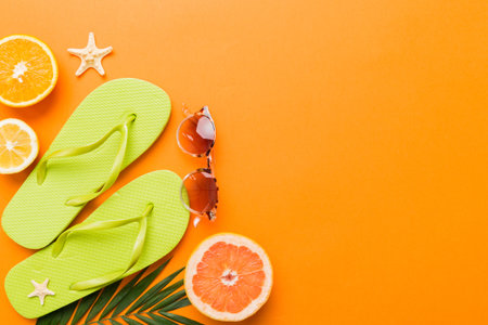 Top view composition of flip flops placed with beach accessories top view on table background....