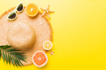 Top view of various seashells placed near colorful fruit and stylish summer accessories on table background. Summer concept. Flat lay. Top view with copy space for text.の写真素材