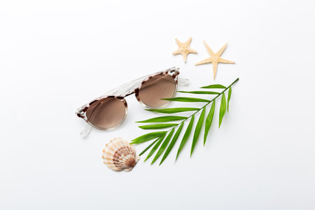 sunglasses with seashell lying on table background. Sunglasses on summer background. Top view flat lay with copy space for text.の写真素材