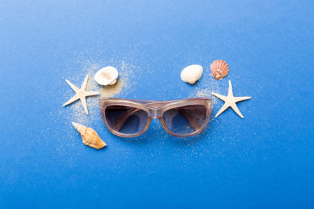 sunglasses with seashell lying on table background. Sunglasses on summer background. Top view flat lay with copy space for text.の写真素材