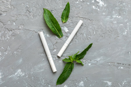 Menthol cigarettes and fresh mint leaves on colored background, Many cigarettes stacked together top view flat lay.の写真素材