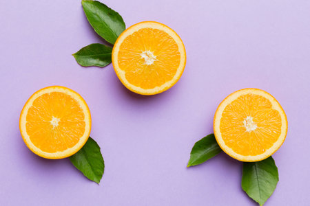 Fruit pattern of fresh orange slices on colored background. Top view. Copy Space. creative summer concept. Half of citrus in minimal flat lay.の写真素材