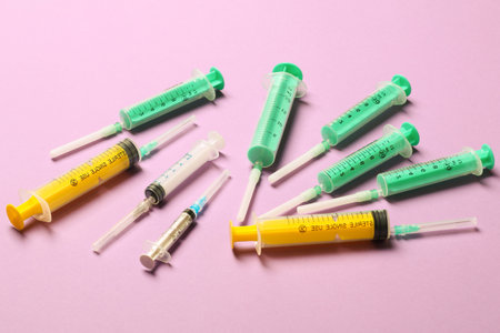 Top view of different syringes at purple background. Medical injection concept with copy space.の写真素材