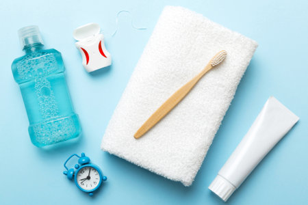 Mouthwash and other oral hygiene products on colored table top view with copy space. Flat lay. Dental hygiene. Oral care products and space for text on light background. conceptの写真素材