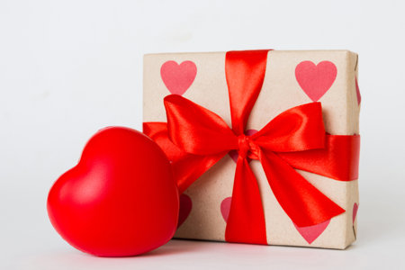 gift box with red bow and red heart on colored background. perspective view. flat lay.の写真素材
