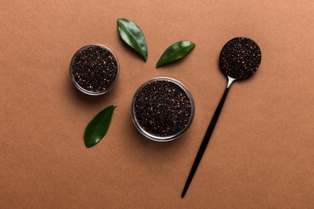 quinoa seeds in bowl and spoon on colored background. Healthy superfood.