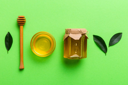 Honey jar with wooden honey dipper on white background top view with copy space.の写真素材