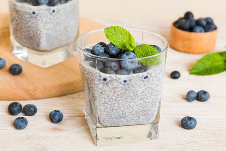 Healthy breakfast or morning with chia seeds vanilla pudding and blueberry berries on table background, vegetarian food, diet and health concept. Chia pudding with coconut milk and blueberry.の写真素材
