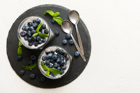 Healthy breakfast or morning with chia seeds vanilla pudding and blueberry berries on table background, vegetarian food, diet and health concept. Chia pudding with coconut milk and blueberry.の写真素材