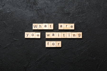 What are you waiting for word written on wood block. What are you waiting for text on cement table for your design, Top view concept.の写真素材