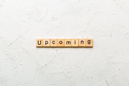UPCOMING word written on wood block. UPCOMING text on cement table for your design, concept.の写真素材