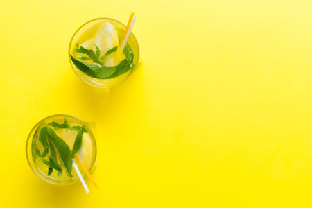 Mojito cocktail, vodka or soda drink with lime, mint and straw on table background. Refreshing beverage with mint and lime in glass top view flat lay.の写真素材