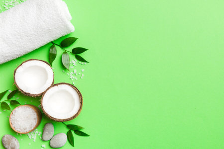 Coconut with jars of coconut oil and cosmetic cream on colored background. Top view. Free space for your text. Natural spa coconut cosmetics and organic treatment concept Coconut Spa composition.の写真素材