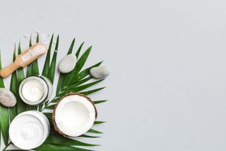 Coconut with jars of coconut oil and cosmetic cream on colored background. Top view. Free space for your text. Natural spa coconut cosmetics and organic treatment concept Coconut Spa composition.の写真素材