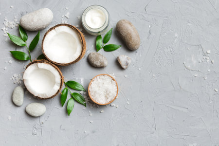 Coconut with jars of coconut oil and cosmetic cream on colored background. Top view. Free space for your text. Natural spa coconut cosmetics and organic treatment concept Coconut Spa composition.の写真素材