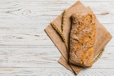 Fresh loaves of bread with wheat and gluten on a colored table. bread on napkin on rustic...