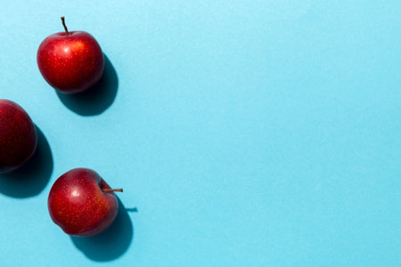 Many red apples on colored background, top view. Autumn pattern with fresh apple above view with copy space for design or text.の写真素材
