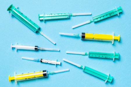 Top view of different syringes at blue background. Medical injection concept with copy space.の写真素材