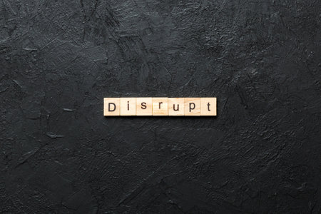 DISRUPT word written on wood block. DISRUPT text on cement table for your design, concept.の写真素材