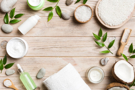 Coconut with jars of coconut oil and cosmetic cream on colored background. Top view. Free space for your text. Natural spa coconut cosmetics and organic treatment concept Coconut Spa composition.の写真素材