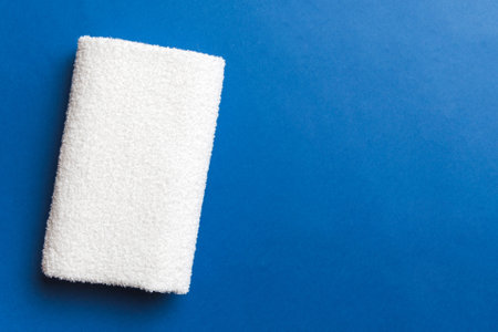 Top view of white towels with copy space on colored background.