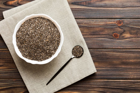 Chia seeds in bowl and spoon on colored background. Healthy Salvia hispanica in small bowl. Healthy superfood.の写真素材