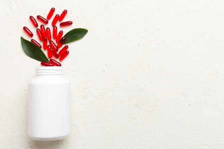 pills poured from a medicine bottle health care and medical top view on colored background.の写真素材