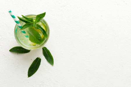 Caipirinha, Mojito cocktail, soda drink with lime, mint and straw on table background. Refreshing...