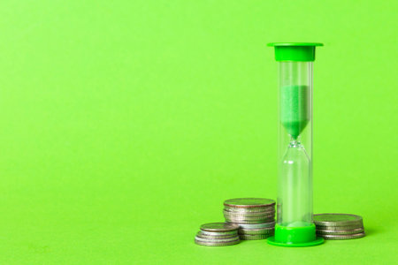 Deadline and time is money concept with hourglass and US coins currency. sand clock time for saving...