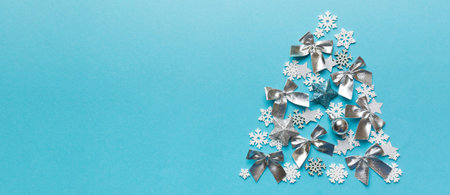 Christmas tree made from colored snowflakes decoration on colored background, view from above. New Year minimal concept.の写真素材