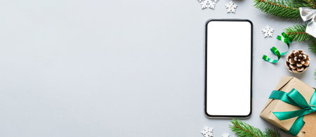 Digital phone mock up with rustic Christmas decorations for app presentation top view with empty space for you design. Christmas online shopping concept. Tablet with copy space on colored background.の写真素材