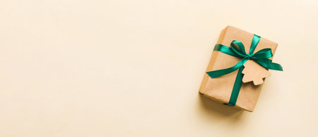 wrapped christmas or other holiday handmade present in paper with colored ribbon. Present box, decoration of gift on colorful table, top view with copy space.の写真素材