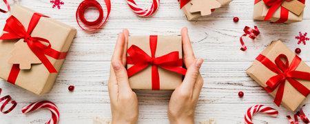 Woman hands holding gift box, preparing surprise for holiday, top view, Christmas and New Year concept.の写真素材