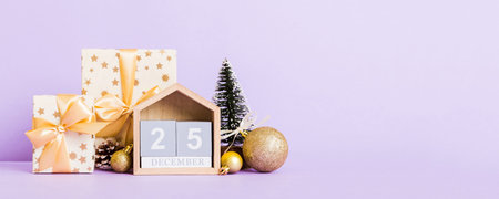 25 december. Christmas composition on colored background with a wooden calendar, with a gift box,...
