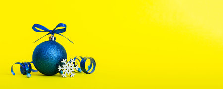 Christmas ball on colored background. decoration bauble with ribbon bow with copy space.の写真素材