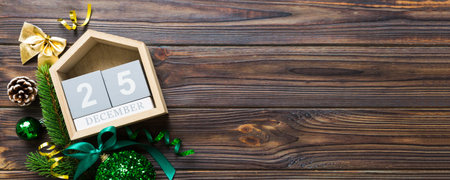 Christmas calendar 25 December. Christmas gift, fir branches, pine cones. Flat lay, top view. New Year decorations on a colored background.の写真素材