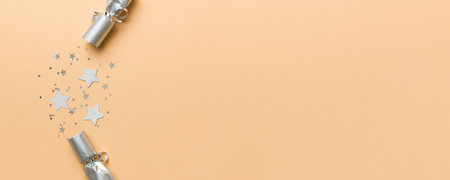 Christmas crackers with shiny confetti on color background, top view, copy space.の写真素材